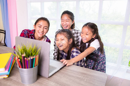 年轻女孩朋友笑并享受学习电脑图片