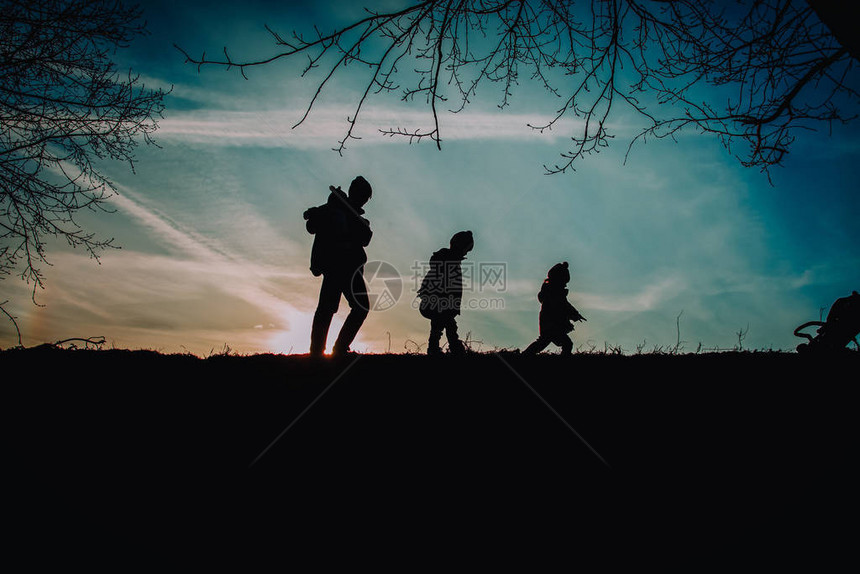 父亲和孩子在日落自然中散步养图片