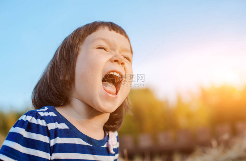 肖像儿童小女孩大声尖叫要求背景设置阳光露天沟通需要孩子的概念欲望情绪化的孩子图片
