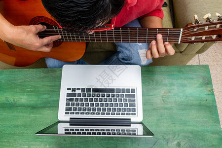 一名在隔离期间在家里接受网上吉他课的人被图片