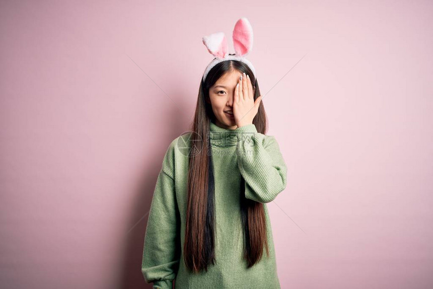 年轻的亚洲女人戴着可爱的复活节耳朵图片