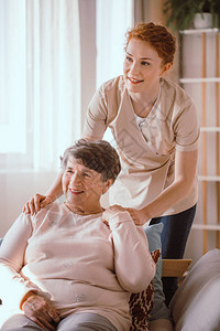 在护理院帮助一名老年妇女的图片