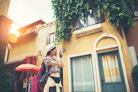 年轻时髦女人背包旅行在城市拍照图片