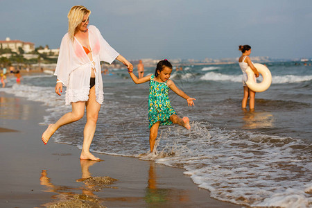 年轻母亲和女儿在沙滩玩耍图片