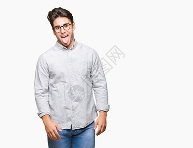 英俊的年轻男人戴着眼镜身穿孤立的背景用有趣的表情来表达快乐的舌图片