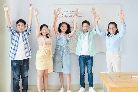兴奋快乐的亚洲学生和他们的科学老师站在白板前图片