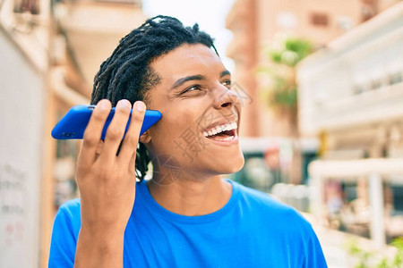 年轻非裔美国人在城市街道上微笑着快乐的听音信息图片