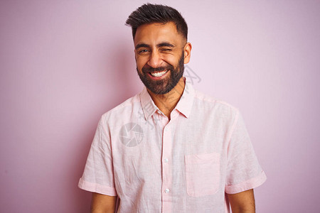 年轻的印度男子穿着休闲衬衫站在孤立的粉红色背景上图片