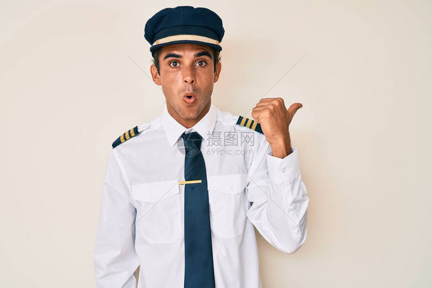 身穿飞机驾驶制服的西班牙年轻人惊讶地用手指向一边图片