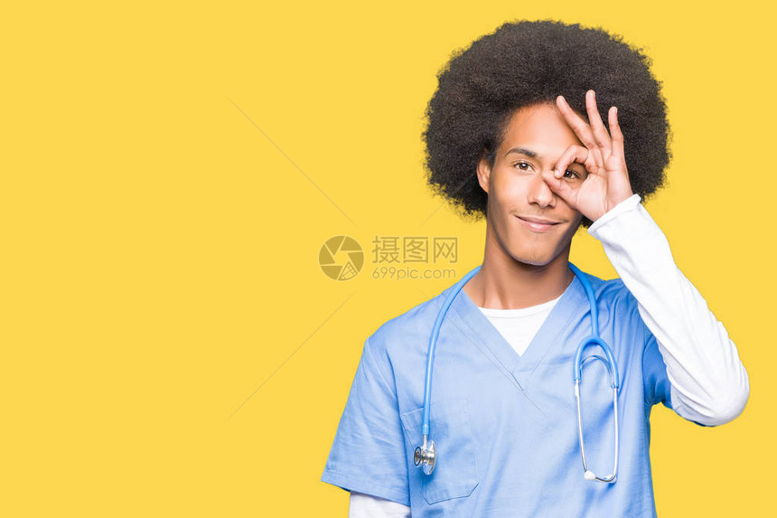 年轻的非洲美籍医生长着头发笑着手的姿势很好眼睛看着手指面图片