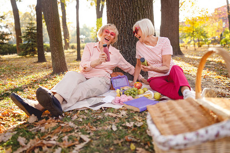 两个开心的女子在野餐时坐图片