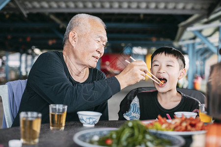 亚洲高级祖父在餐厅喂孙子图片