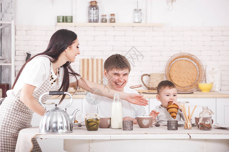 幸福的家庭一起做饭年轻的父母和他们的孩子吃早餐人图片