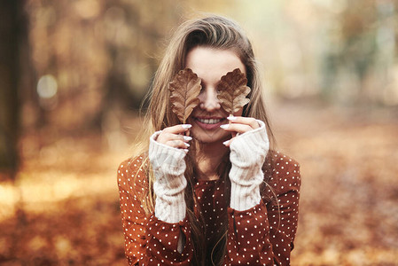 用秋叶遮住眼睛的女人图片