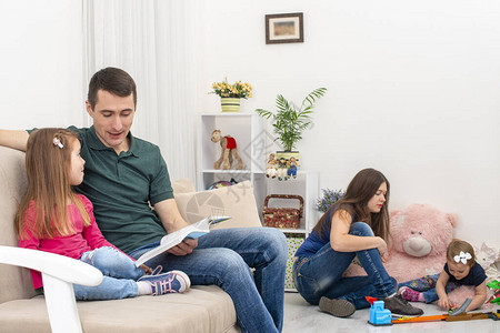 年轻家庭与两个年幼的孩子在家里消磨时光的镜头家庭价值观的概图片