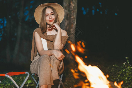 女孩穿着温暖的时装在壁炉附近晚上浪漫的周末在图片