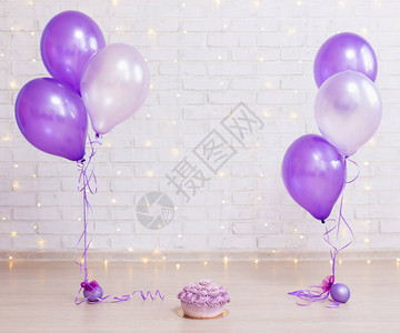 生日派对概念用灯光和紫气球在砖墙图片