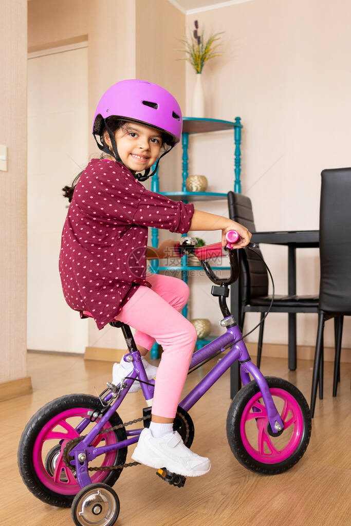 小女孩在她的客厅里骑自行车图片