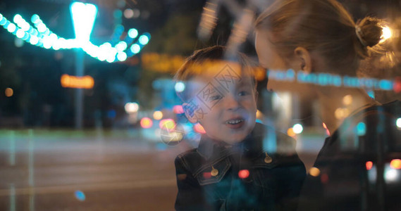 晚上在繁忙的街道上的儿子和母亲图片