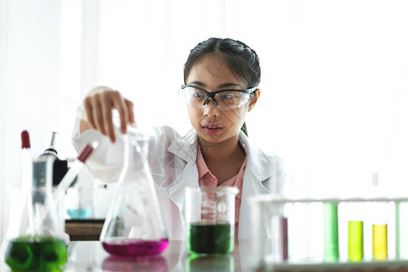 十几岁的女学生在桌上的科学课上学习和做化学实验背景图片