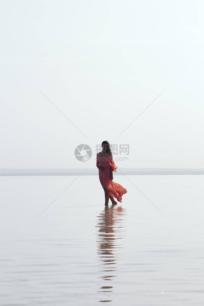 日落时在海上行走的女子海滩暑假渡图片