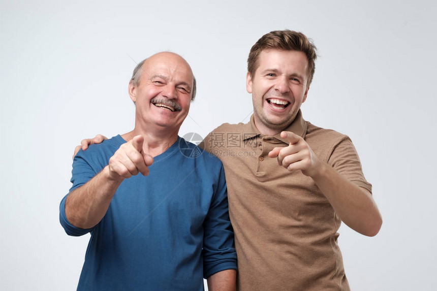 两个欧洲男人的父亲和儿子用食指对着照相机图片