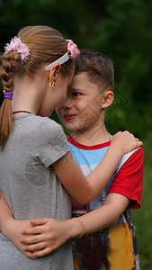 可爱的小女孩和男孩拥抱彼此并看着对方的眼睛第一童年时期关系图片