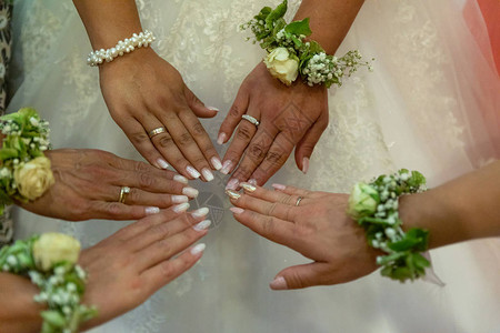 新娘和她的伴娘吹嘘戒指和美甲图片