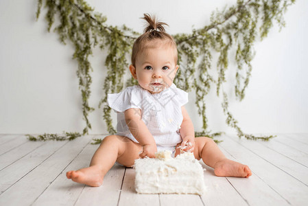 女婴一岁生日蛋糕在白背景和白蛋糕的白图片