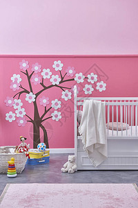 带有床和玩具的新儿童房间粉红色墙壁和树木图案图片