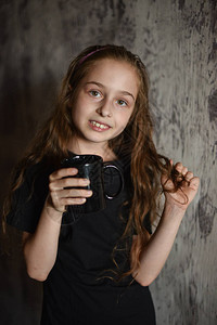 小女孩一个穿着黑色t恤拿着一杯咖啡图片