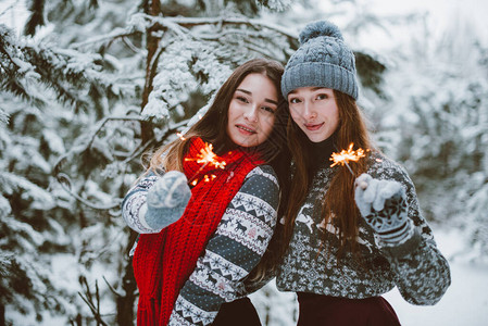 在户外雪地拿着烟花拍照的两个女孩图片