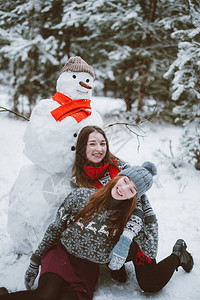 与雪人一起亲密拍照的女孩们图片