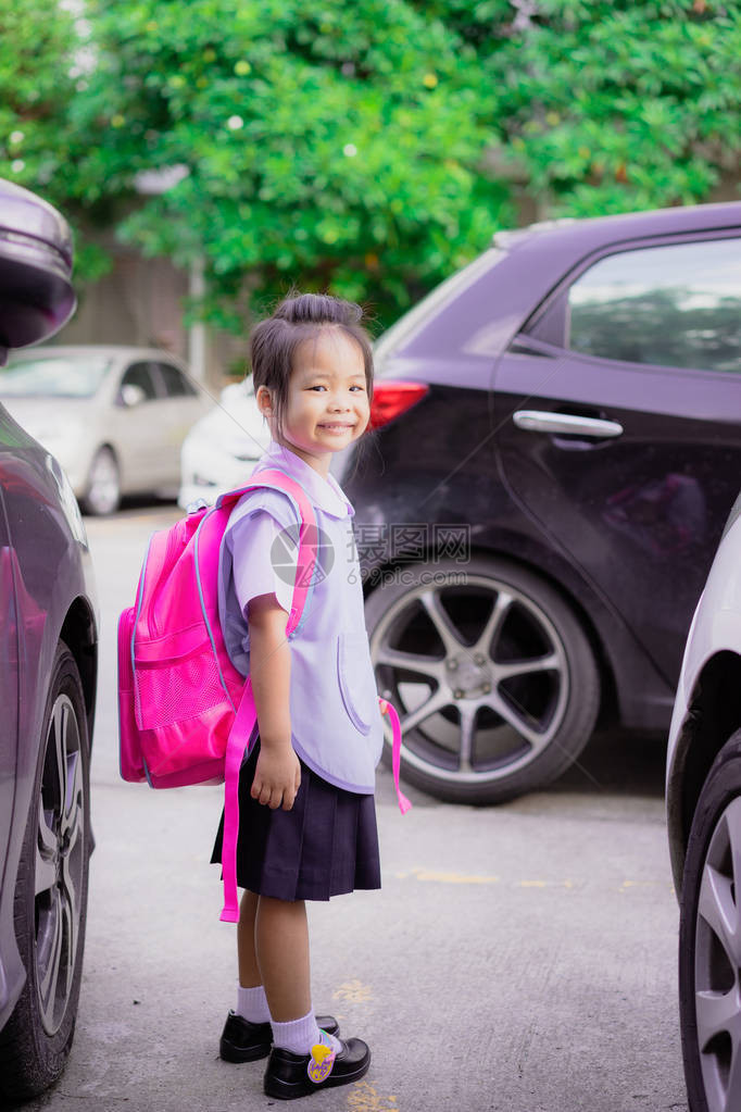 身穿泰国校服背包站在停车场的快乐图片