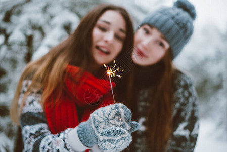 女孩们在户外雪地拿着烟花拍照图片