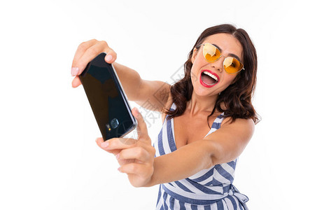 青年妇女使用电话身戴太阳眼图片
