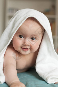可爱的婴儿躺在她的上在一条白毛巾图片