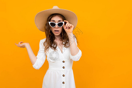 穿着白衣服草帽和墨镜的橘橙色女郎在图片
