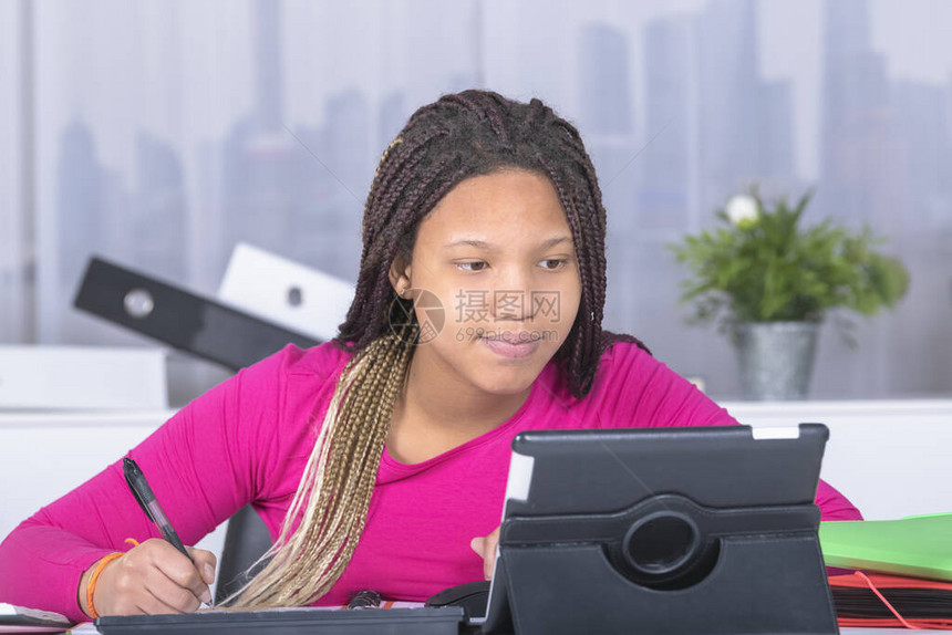 带着毛发的漂亮女孩用平板电脑和笔做功课在失去焦点的背景教育概图片