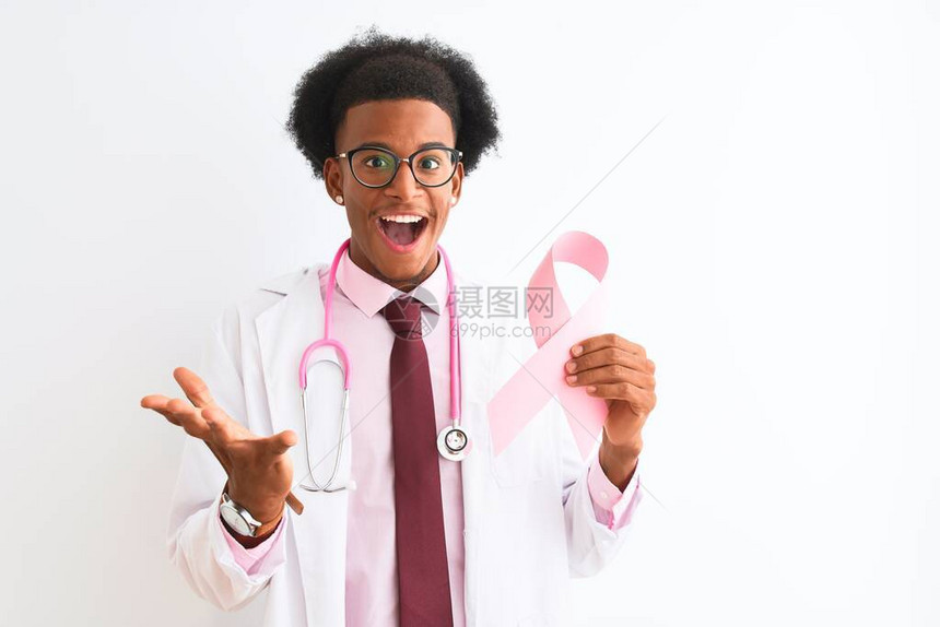年轻的非洲裔美国医生拿着癌症丝带在孤立的白色背景上非常高兴和奋图片