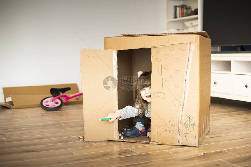 小女孩在搬进新房子时从纸板游戏图片