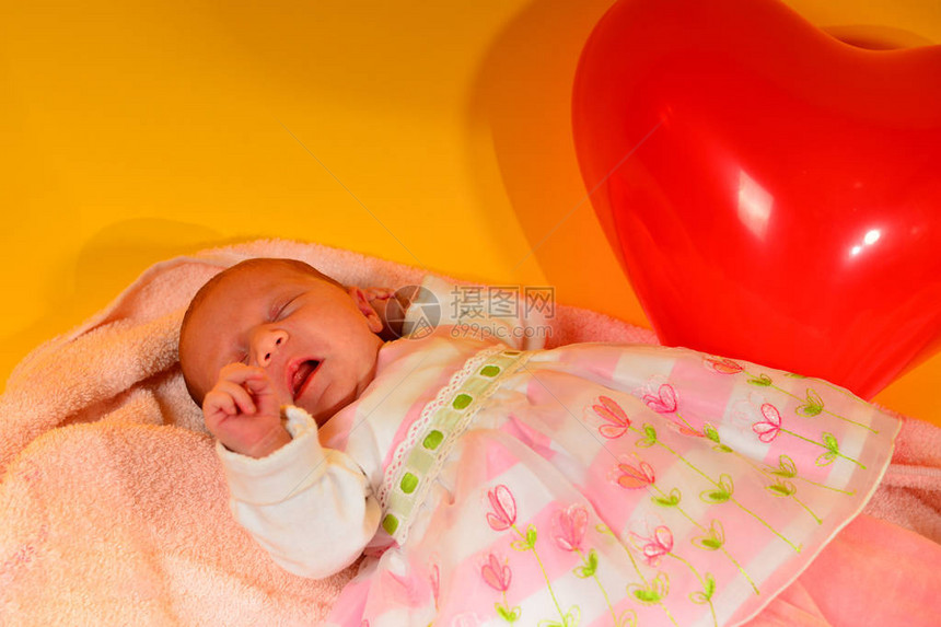 新生婴儿躺在粉红色摇篮曲中背着背景图片