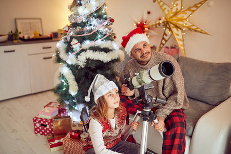 父亲和女儿在圣诞节新年节时看着望远镜图片