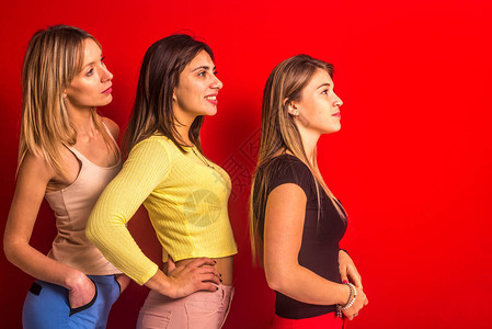在红墙前排成一排的三个女孩一张在另一图片