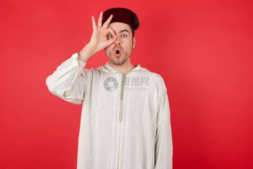 英俊的年轻人戴着传统的土耳其帽子fez做着ok的手势图片