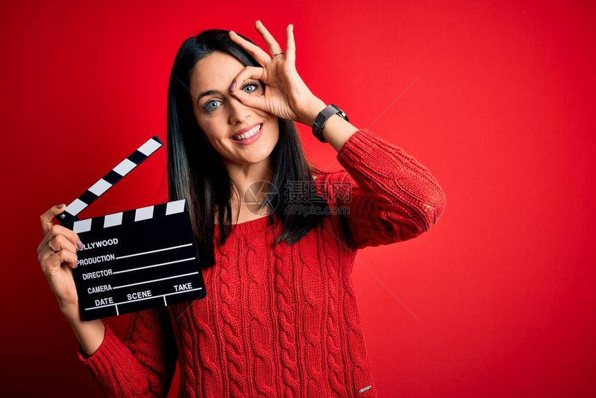 蓝眼睛的年轻导演女导演在红色背景上拿着隔板图片