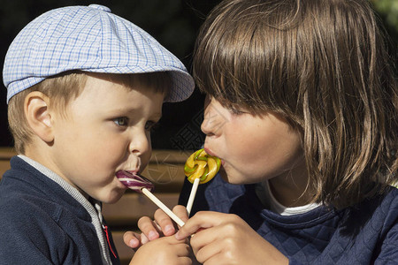 男孩和女孩吃美味的棒糖可爱的图片