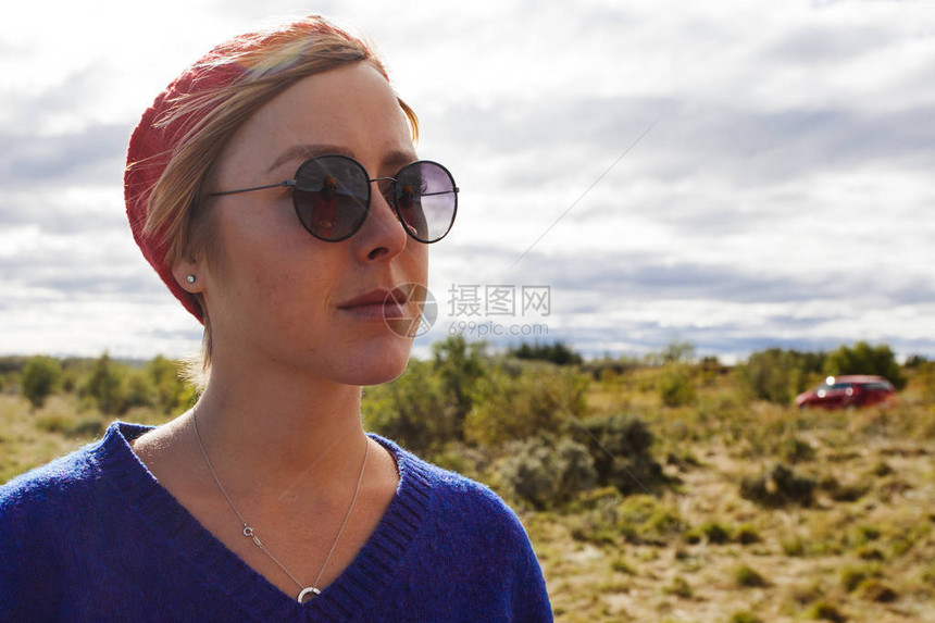 身戴太阳镜和红运动帽的年轻女子图片