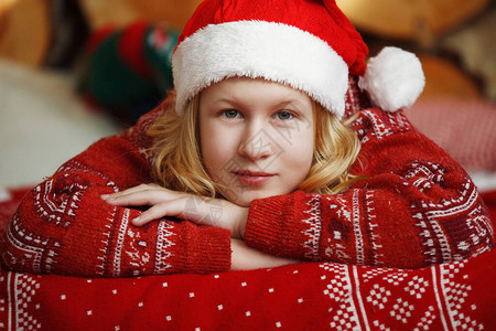 穿着红色圣诞毛衣的少女戴着帽子撒谎图片