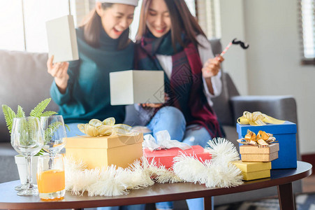 餐桌上的礼品盒与两个快乐的亚洲女孩最好的朋友一起打开礼物图片